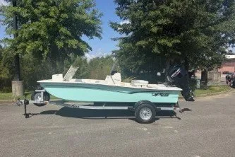 The Image of 2026 Mako Pro Skiff 15 CC boat on trailer, parked outdoors near trees. - 0