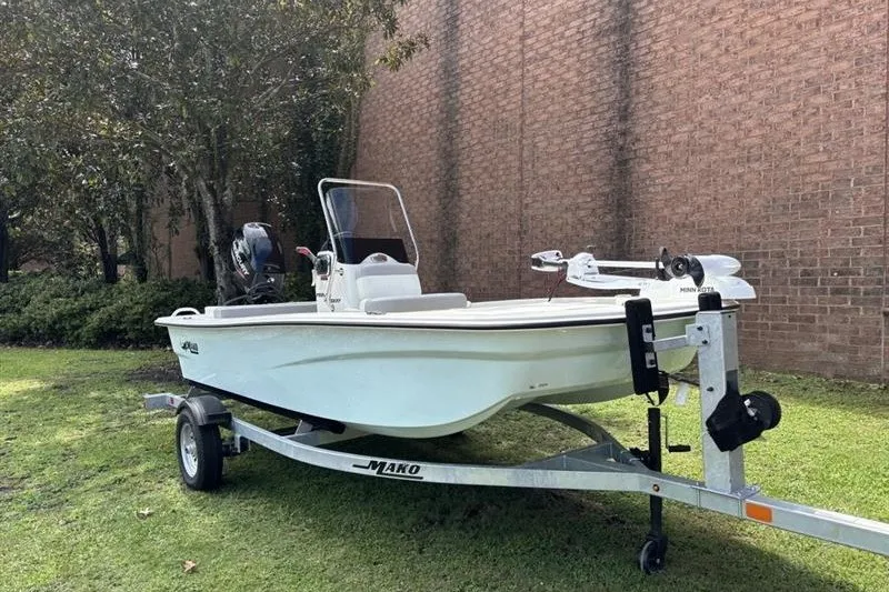 The Image of 2026 Mako Pro Skiff 13 CC boat on trailer, parked on grass near brick wall. - 0
