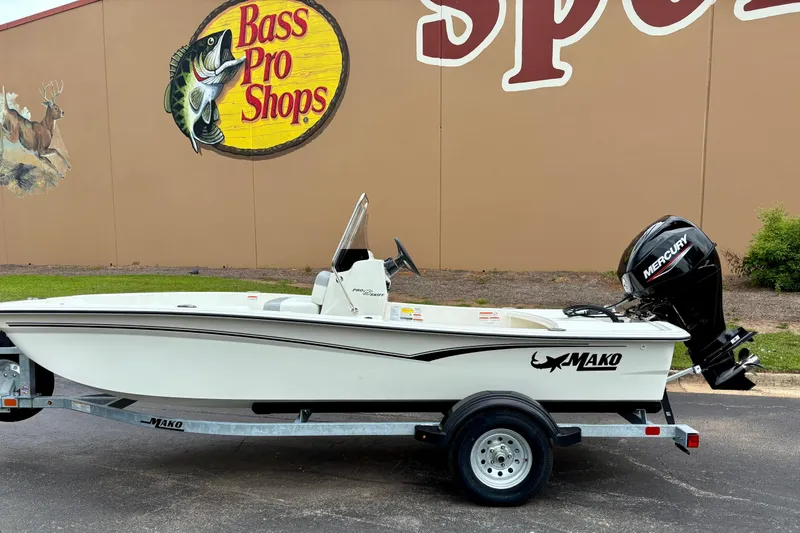 The Image of 2026 Mako Pro Skiff 15 CC boat on trailer, parked outside Bass Pro Shops. - 0