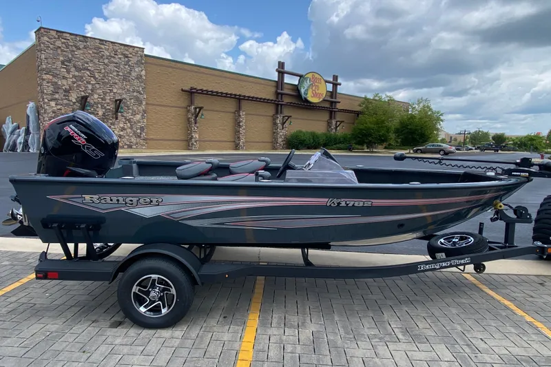 Slide: The Image of 2026 Ranger VS1782SC Angler boat on trailer, parked outside Bass Pro Shops. - 1