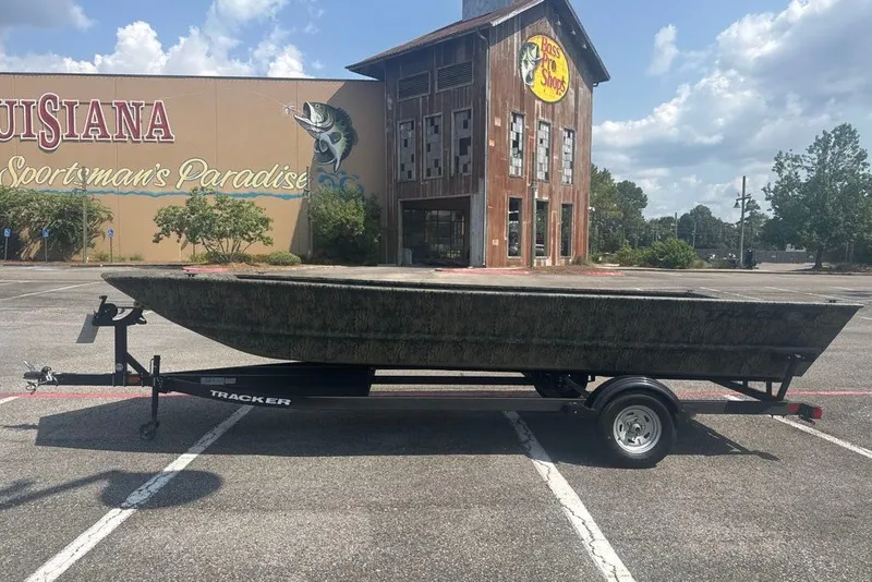 Slide: The Image of 2026 Tracker Grizzly 2072 Utility boat on trailer, parked outside Bass Pro Shops. - 2