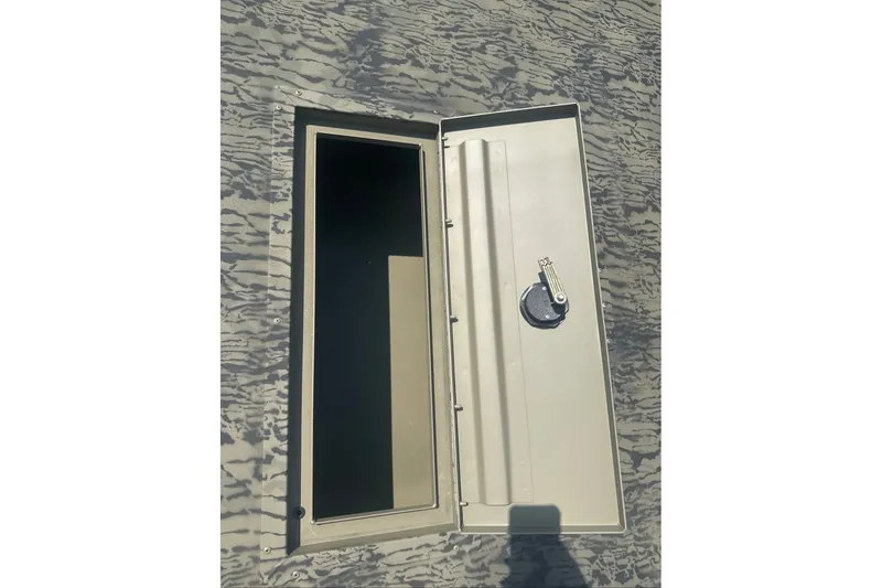 Slide: The Image of Open storage compartment on 2026 Tracker Grizzly 2072 Utility boat, featuring camouflage pattern. - 8