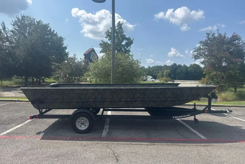 The Image of 2026 Tracker Grizzly 2072 Utility boat on trailer in parking lot under blue sky. - 0