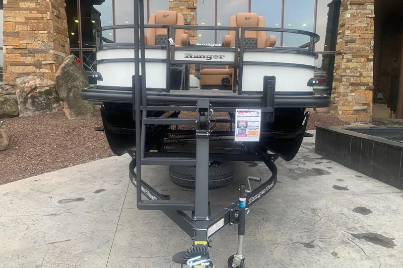 Slide: The Image of 2026 Ranger 220F boat on trailer, displayed outdoors near stone building. - 2