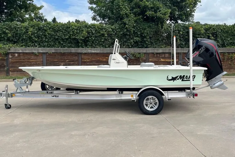 Slide: The Image of 2026 Mako 18 Pro Skiff boat on trailer, parked outdoors. - 1