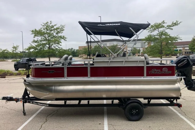 Slide: The Image of 2026 Sun Tracker Bass Buggy 18 DLX pontoon boat on trailer in parking lot. - 8