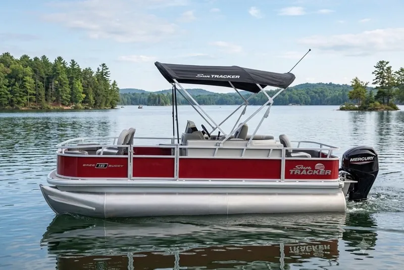 The Image of 2026 Sun Tracker Bass Buggy 18 DLX pontoon boat on a scenic lake. - 1