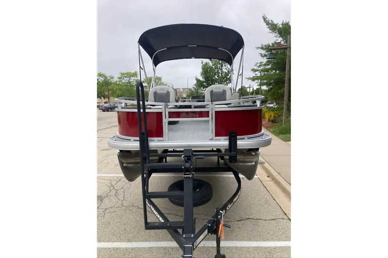 Slide: The Image of 2026 Sun Tracker Bass Buggy 18 DLX pontoon boat on trailer, rear view. - 2