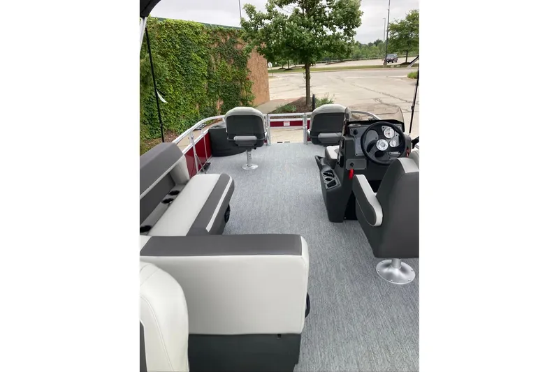 Slide: The Image of 2026 Sun Tracker Bass Buggy 18 DLX pontoon boat interior with seating and steering console. - 5