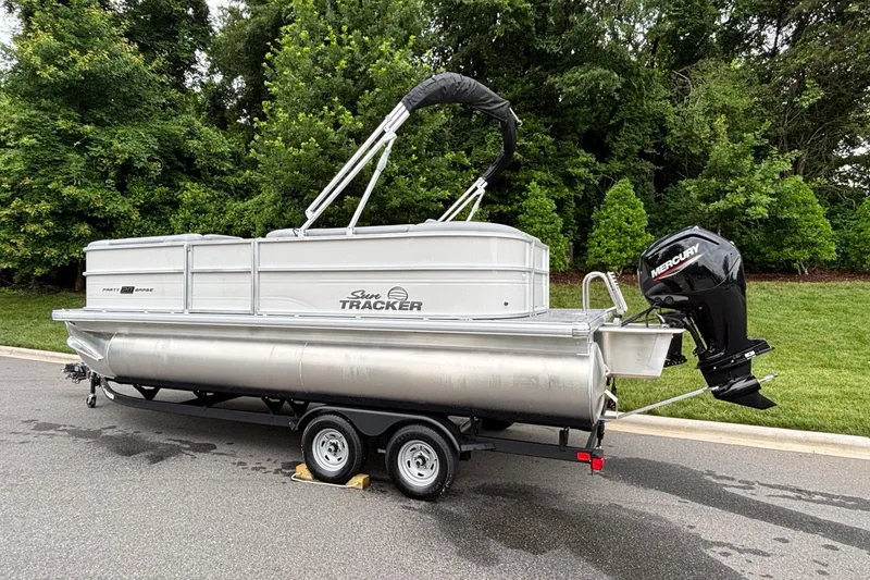 Slide: The Image of 2026 Sun Tracker Party Barge 20 DLX pontoon boat on trailer, parked outdoors. - 3