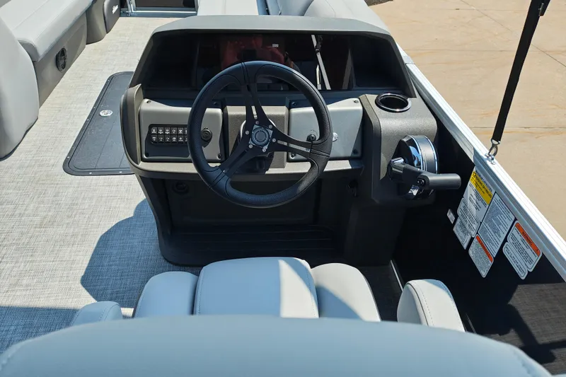 Slide: The Image of 2026 Sun Tracker Party Barge 24 XP3 helm with steering wheel and control panel. - 17