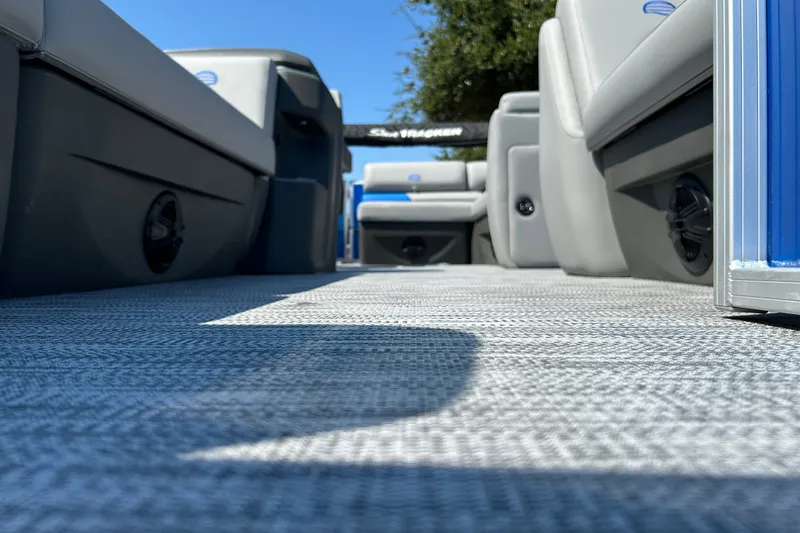 Slide: The Image of 2026 Sun Tracker Party Barge 20 DLX interior with gray seating and textured flooring. - 19