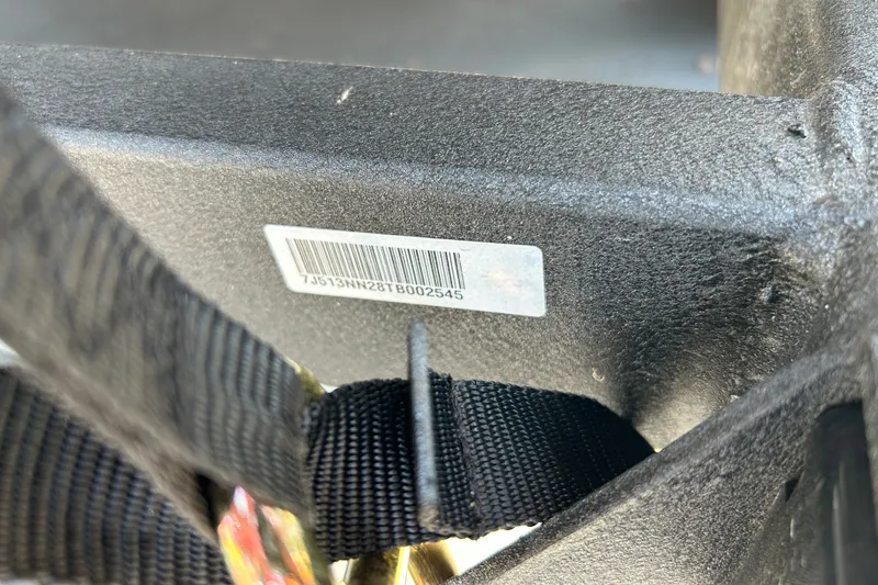 Slide: The Image of Close-up of a boat part with a barcode and a black strap. - 99
