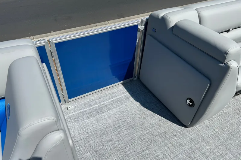 Slide: The Image of 2026 Sun Tracker Party Barge 20 DLX interior with gray seating and blue panel. - 18