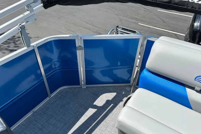 Slide: The Image of 2026 Sun Tracker Party Barge 20 DLX interior with blue panels and gray seating. - 14