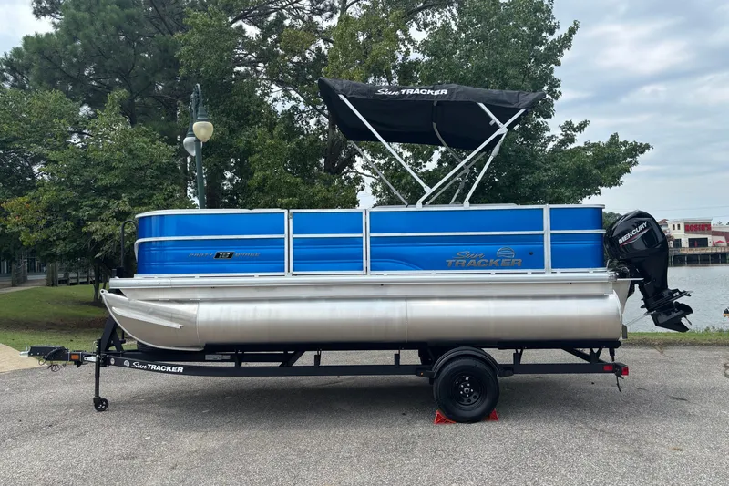 The Image of 2026 Sun Tracker Party Barge 18 DLX pontoon boat on trailer, parked outdoors. - 0