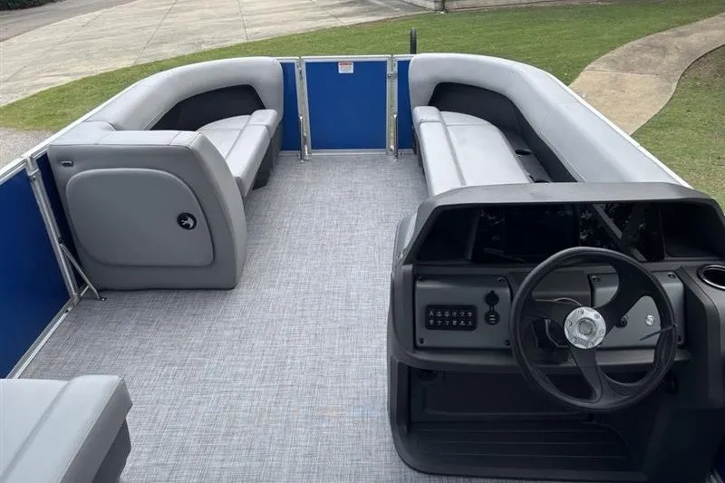 Slide: The Image of 2026 Sun Tracker Party Barge 18 DLX interior with gray seating and steering console. - 10
