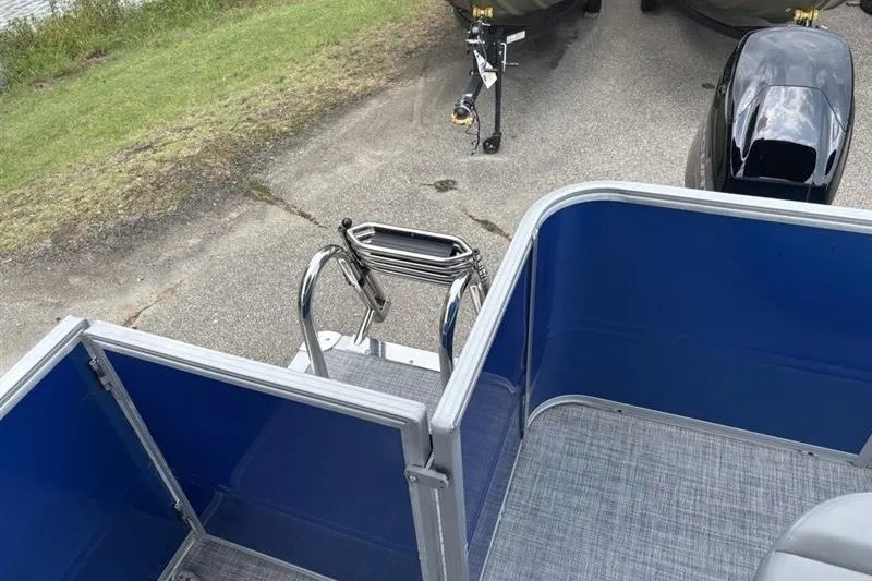 Slide: The Image of 2026 Sun Tracker Party Barge 18 DLX pontoon boat with blue panels and ladder. - 24