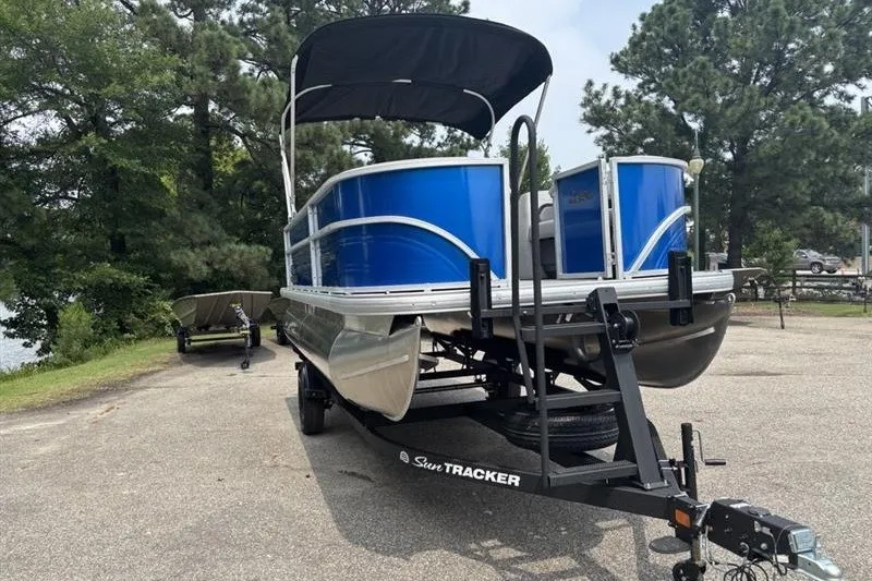 Slide: The Image of 2026 Sun Tracker Party Barge 18 DLX pontoon boat on trailer, parked outdoors. - 4