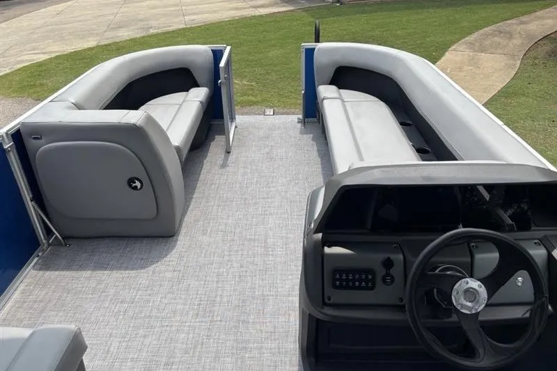 Slide: The Image of 2026 Sun Tracker Party Barge 18 DLX interior with gray seating and steering console. - 11