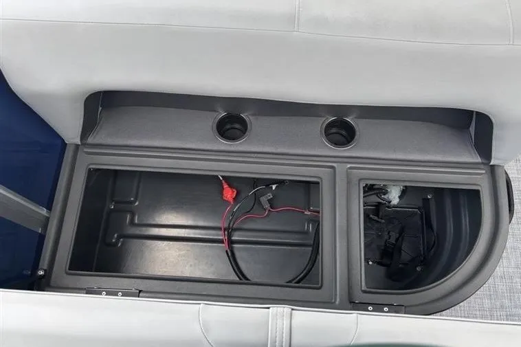 Slide: The Image of Storage compartment of 2026 Sun Tracker Party Barge 18 DLX with cup holders and wiring. - 23