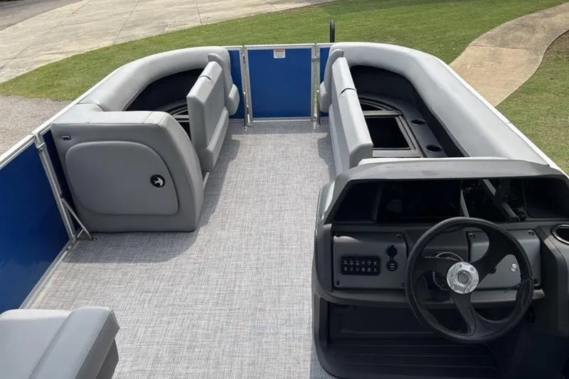 Slide: The Image of 2026 Sun Tracker Party Barge 18 DLX interior with gray seating and steering console. - 12