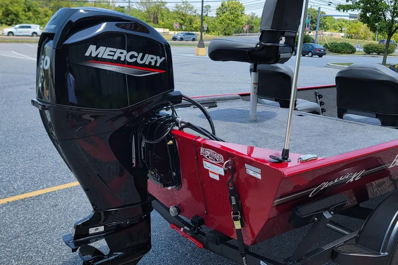 Slide: The Image of 2025 Tracker Bass Tracker Classic XL with Mercury outboard motor in parking lot. - 3
