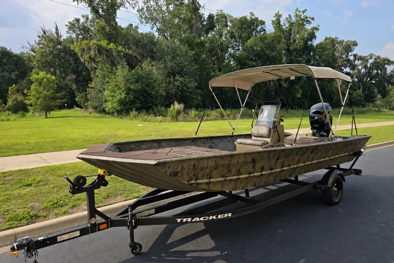 The Image of 2026 Tracker Grizzly 2072 CC boat on trailer, parked on a road near lush greenery. - 0