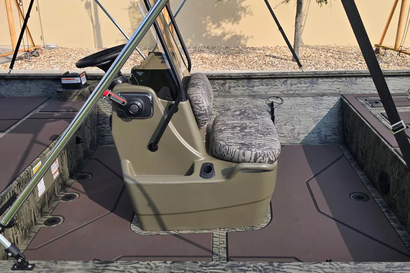 Slide: The Image of 2026 Tracker Grizzly 2072 CC boat interior with camouflage seating and steering console. - 3