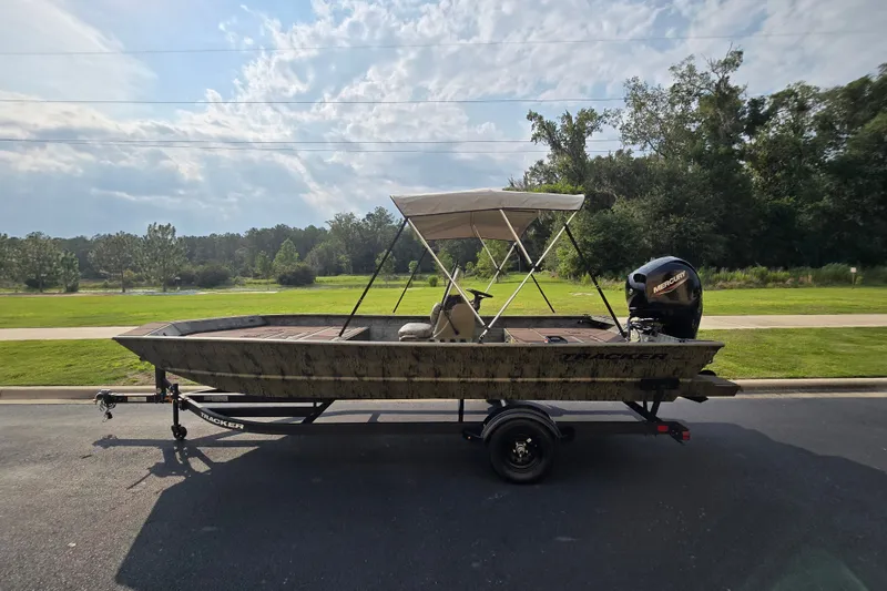 Slide: The Image of 2026 Tracker Grizzly 2072 CC boat on trailer, parked outdoors under cloudy sky. - 9