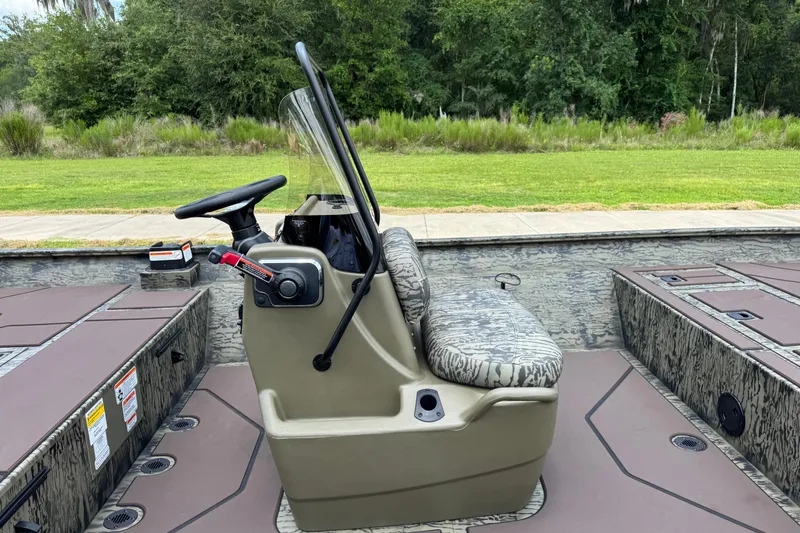 Slide: The Image of 2026 Tracker Grizzly 2072 CC boat interior with steering console and camouflage seating. - 12