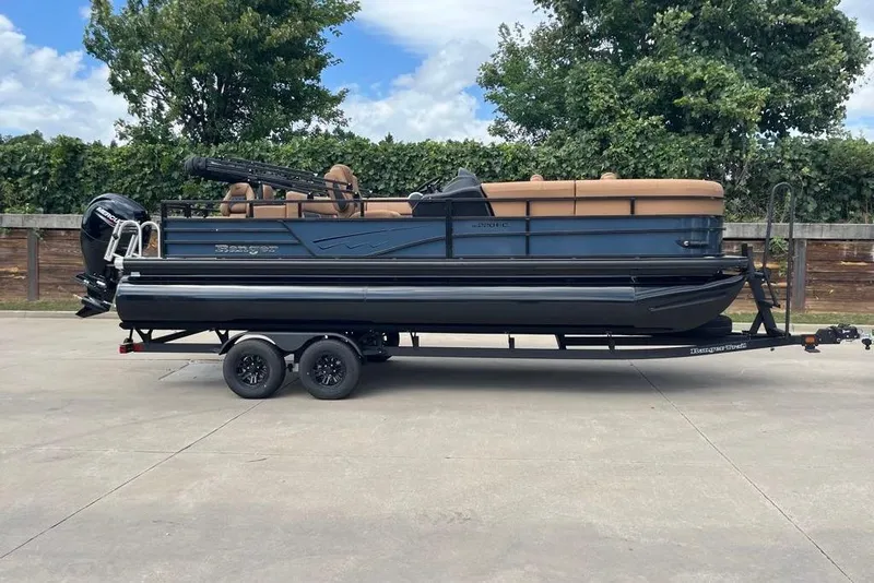 The Image of 2026 Ranger 220FC pontoon boat on trailer, parked outdoors with trees in background. - 0