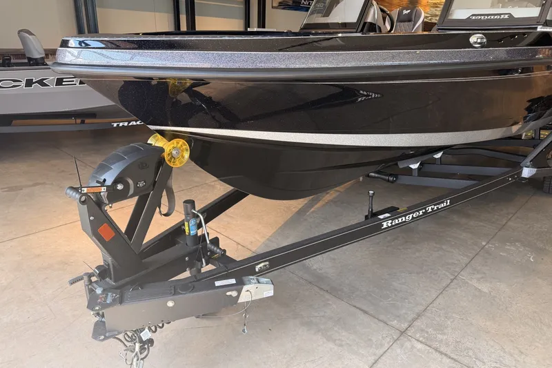 Slide: The Image of 2026 Ranger 621FS Cup-Equipped boat on trailer, sleek black design in showroom. - 7