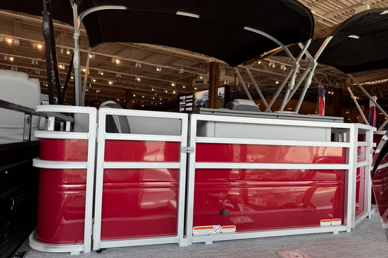 The Image of 2026 Sun Tracker Bass Buggy 18 DLX pontoon boat with red exterior in showroom. - 0