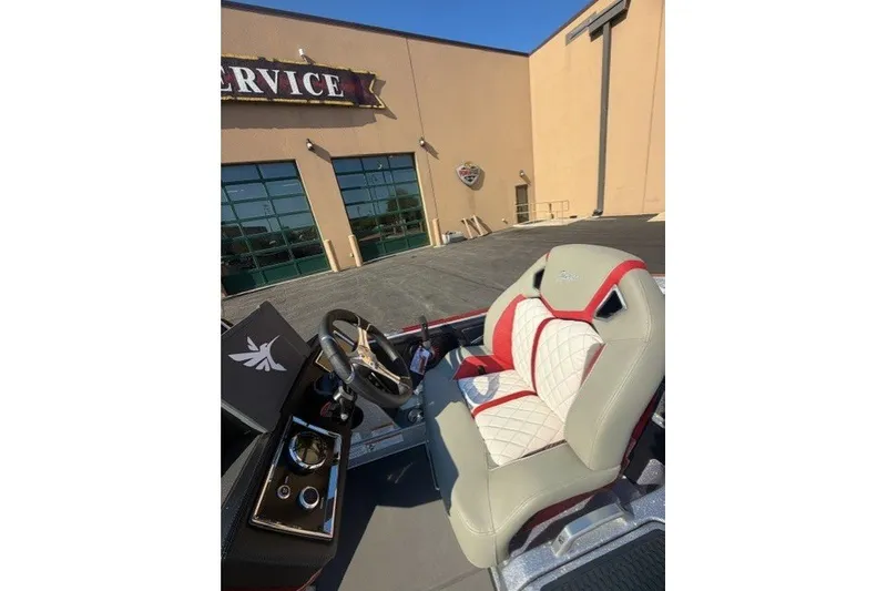 Slide: The Image of 2026 Ranger Z520R boat interior with stylish red and white seating, parked outside service center. - 8