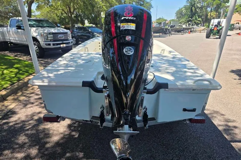 Slide: The Image of 2026 Mako 18 Pro Skiff with outboard motor, parked outdoors on a sunny day. - 6