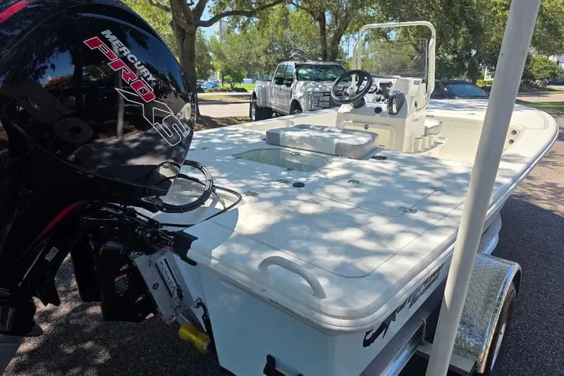 Slide: The Image of 2026 Mako 18 Pro Skiff boat with Mercury Pro XS engine in a sunny outdoor setting. - 2