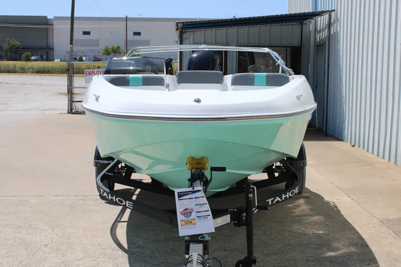 Slide: The Image of 2026 Tahoe T16 boat on trailer, parked outdoors near a metal building. - 3