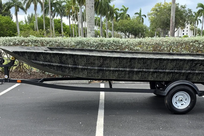 The Image of 2026 Tracker Grizzly 1754 Utility boat on trailer, parked in a tropical setting. - 0