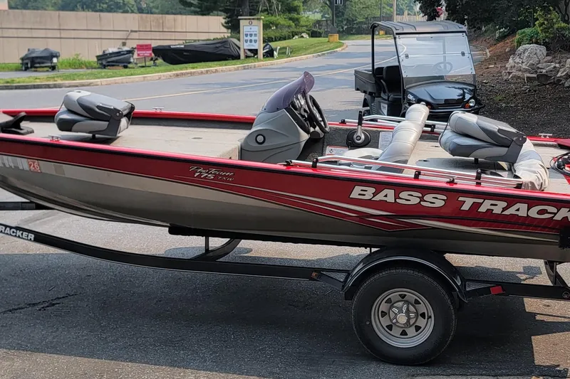 Slide: The Image of 2013 Tracker Pro Team 175 TXW bass boat on trailer, parked outdoors. - 9