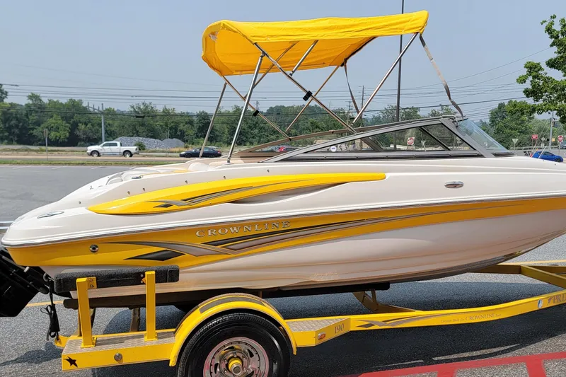 Slide: The Image of 2007 Crownline 19 SS boat with yellow accents and canopy on a trailer. - 2