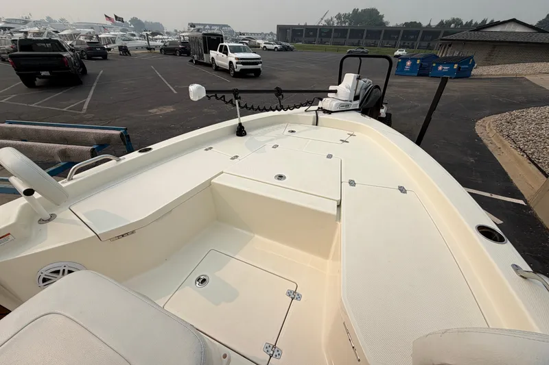 Slide: The Image of 2024 Pathfinder 2200 TRS boat interior, showcasing spacious deck and seating in a marina setting. - 13