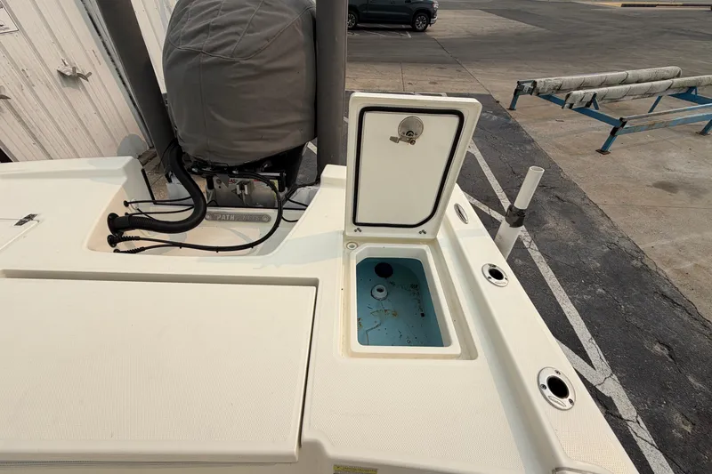 Slide: The Image of 2024 Pathfinder 2200 TRS boat with open storage compartment and covered engine. - 17