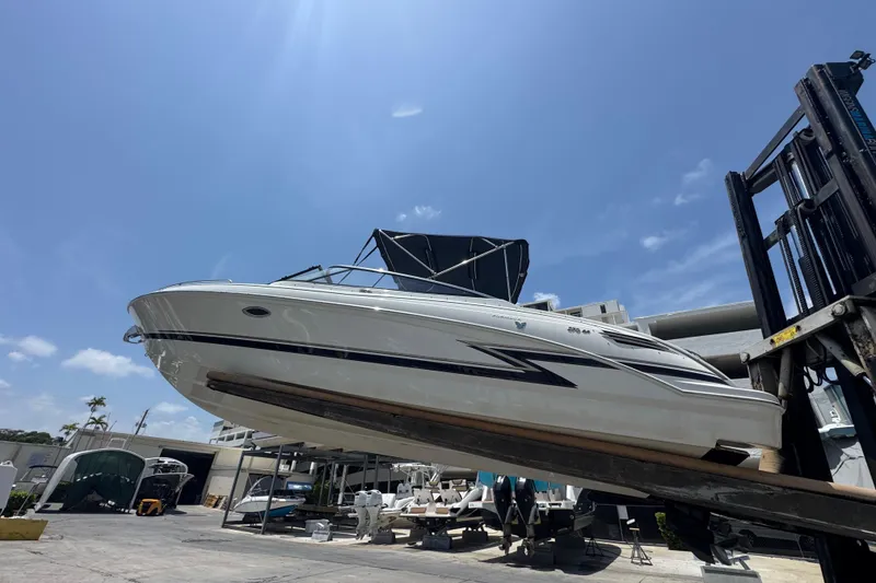 Slide: The Image of 2019 Formula 270 Bowrider boat lifted by forklift under clear blue sky. - 6
