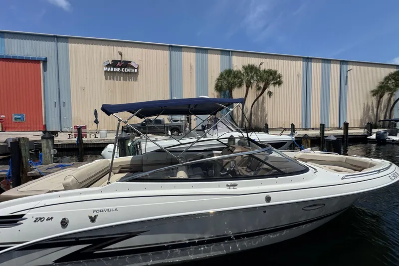 Slide: The Image of 2019 Formula 270 Bowrider docked at a marina with a blue canopy. - 8