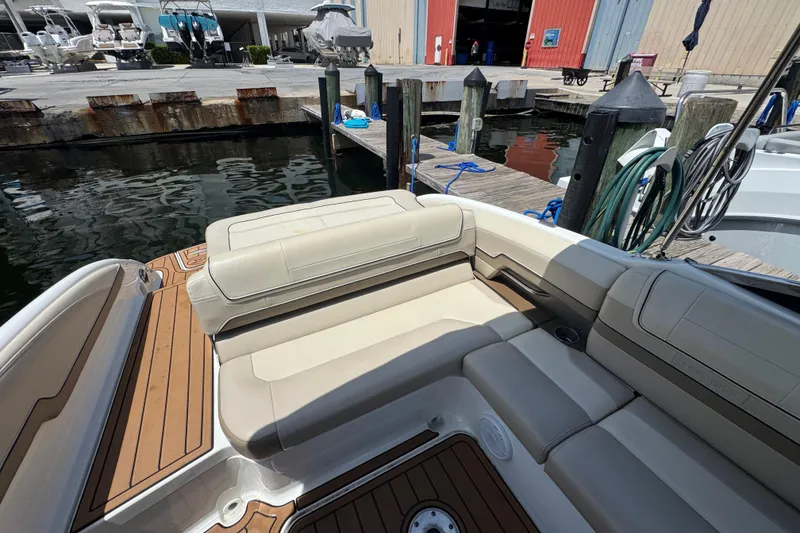 Slide: The Image of 2019 Formula 270 Bowrider boat interior with beige seating at a marina dock. - 19