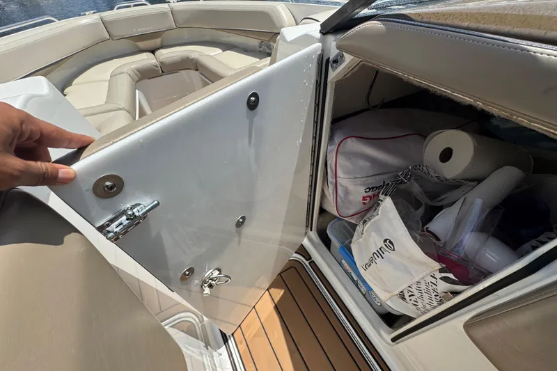 Slide: The Image of 2019 Formula 270 Bowrider storage compartment with various items, including paper towels and bags. - 41