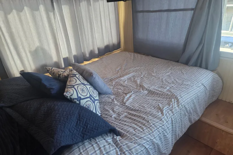 Slide: The Image of Cozy bedroom in 1973 River Queen Star Stream with nautical-themed pillows and soft lighting. - 16