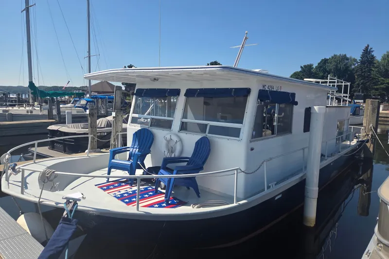 The Image of 1973 River Queen Star Stream boat docked with blue chairs and American flag rug. - 0