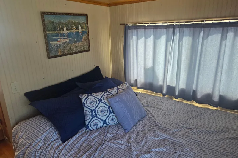 Slide: The Image of Cozy bedroom in 1973 River Queen Star Stream with nautical-themed decor and blue curtains. - 17